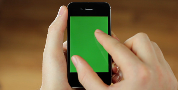 Mobile phone in hand with green screen