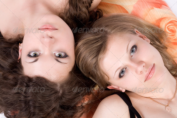 Portrait of the two beauty young women laying on a pillow 1 - Stock Photo - Images