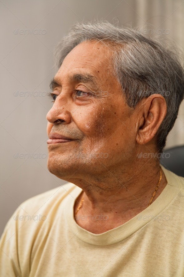 Portrait of old Indian Asian man seated in casual dress