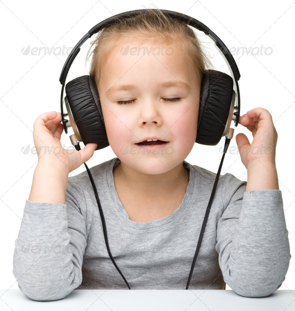 Cute girl enjoying music using headphones - Stock Photo - Images
