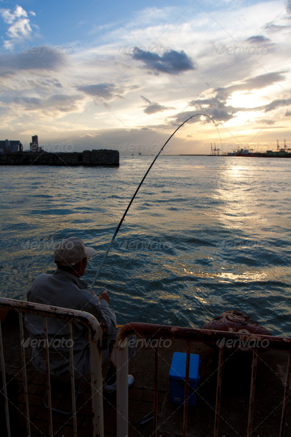 Man fishing during sunset - Stock Photo - Images