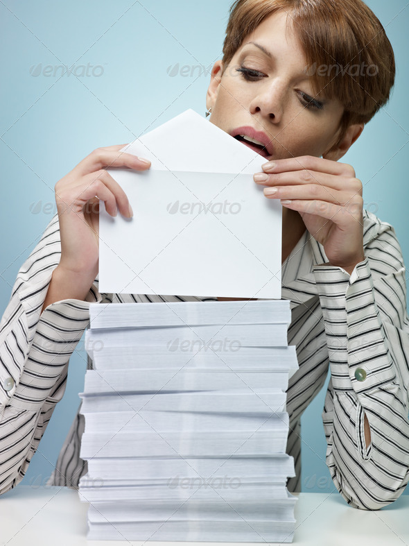 caucasian secretary closing pile of envelopes. Vertical shape, front view, waist up, copy space