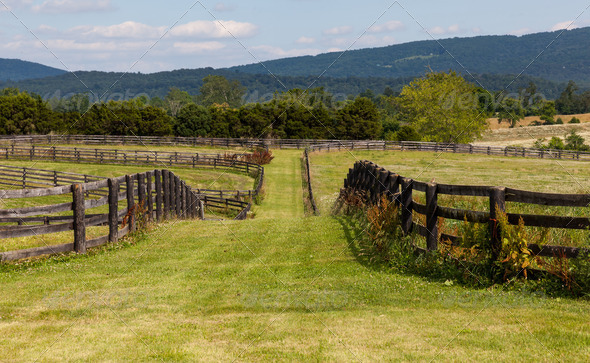 Rolling meadows with wooden fences and hills - Stock Photo - Images