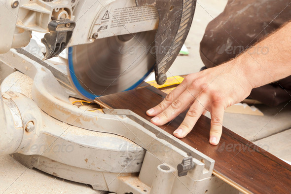Contractor Using Circular Saw Cutting of New Laminate Flooring Renovation. - Stock Photo - Images
