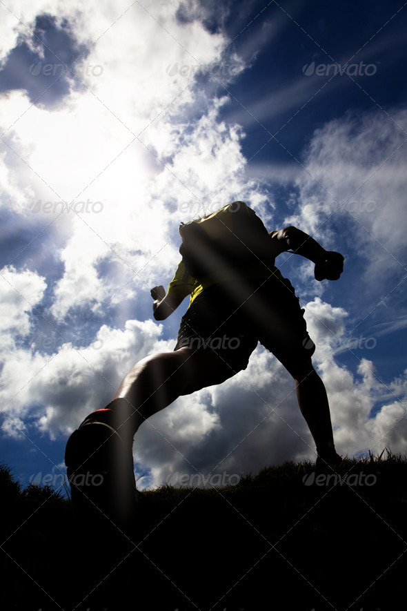 The Silhouette of runner on the grass field with sunlight background - Stock Photo - Images