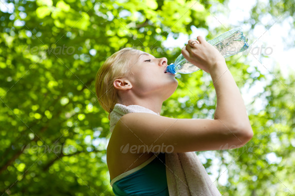 Portrait of beautiful smiling woman with bottle of water - Stock Photo - Images