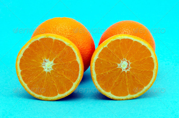 Orange fruit full and sectioned on blue background - Stock Photo - Images