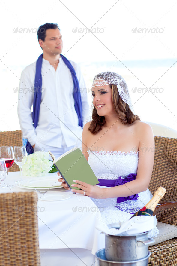 Couple in wedding day woman reading book on banquet - Stock Photo - Images