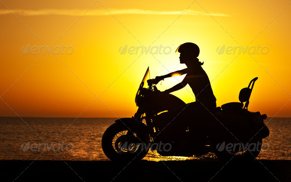 Woman biker over sunset - Stock Photo - Images