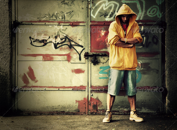 Young man in hooded sweatshirt on grunge wall - Stock Photo - Images