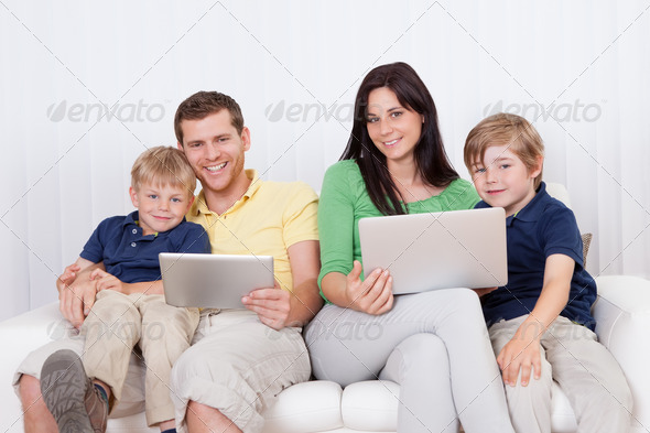 Happy family using laptop at home - Stock Photo - Images