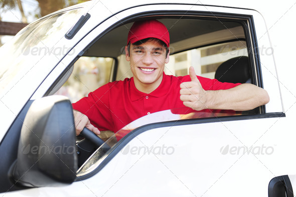 male postal delivery courier in a van showing thumb up hand sign