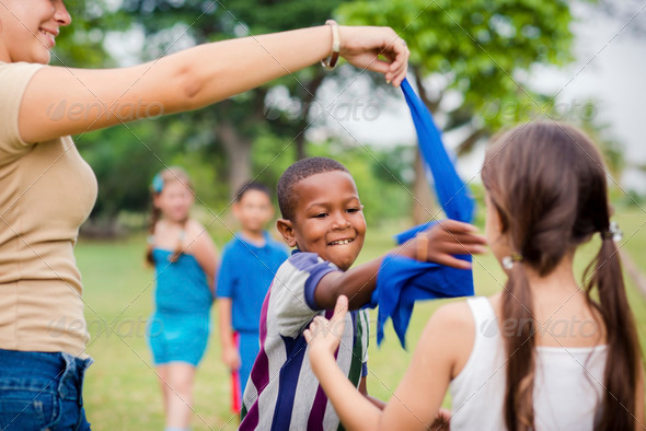 Children and teacher playing games in city park - Stock Photo - Images