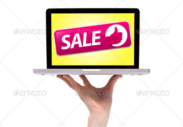 a male hand holding a laptop with sale sign - Stock Photo - Images