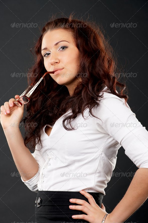 Portrait of young female holding glasses in hand - Stock Photo - Images
