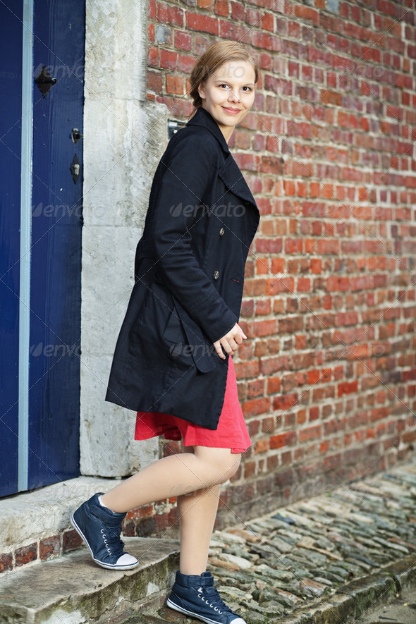 Young woman walks out of the door - Stock Photo - Images