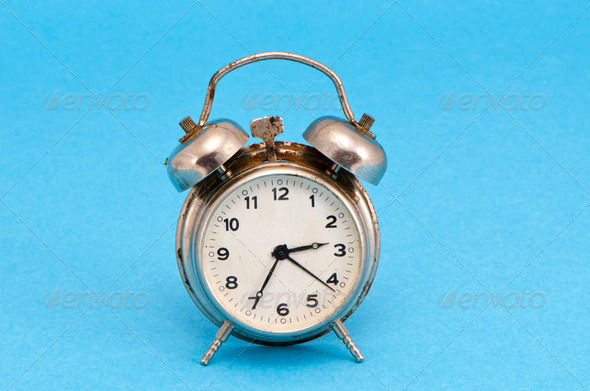 Retro grunge rusty alarm clock blue background - Stock Photo - Images