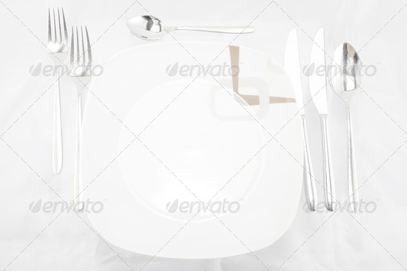 Plates with a silver fork, spoon, dessert spoon and a knife - Stock Photo - Images