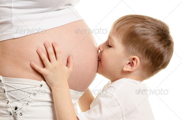 Young boy is kissing the pregnant woman - Stock Photo - Images