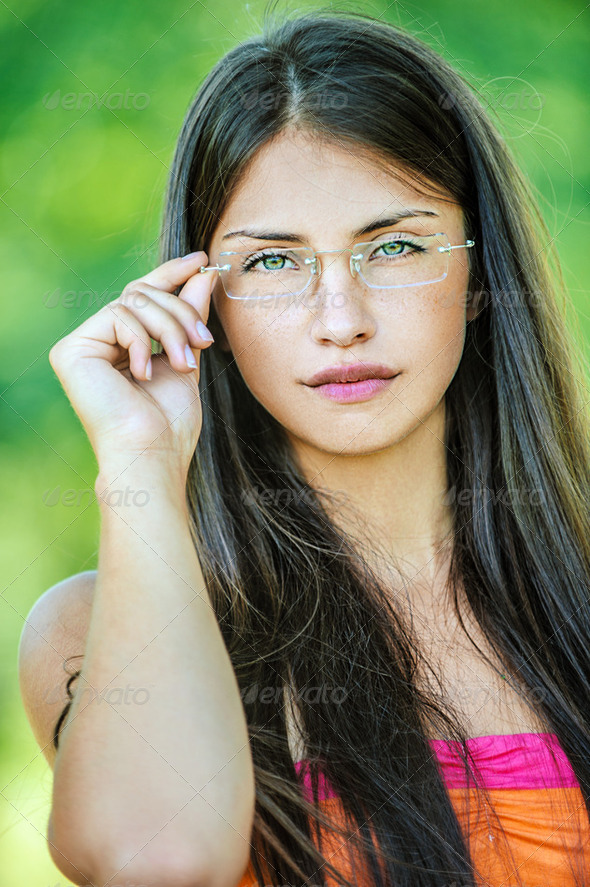 young beautiful woman adjusts glasses - Stock Photo - Images