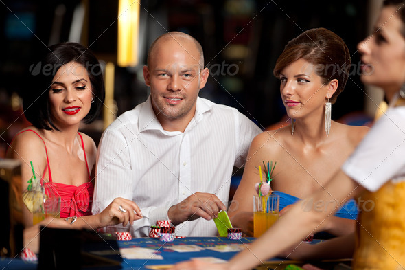 handsome blackjack player with two elegant women - Stock Photo - Images