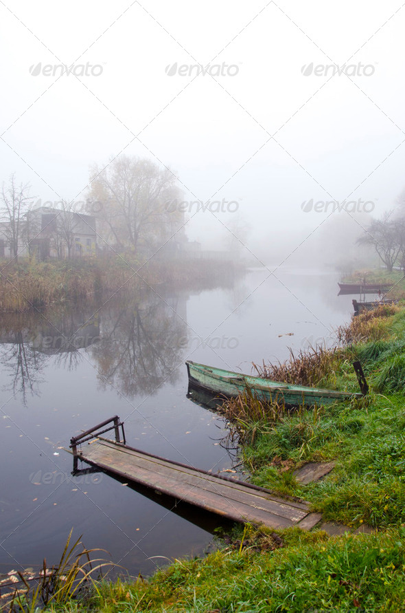 Wooden boat and bridge on river sunken in fog - Stock Photo - Images