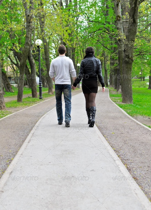 Couple walking down the road in the park. From the back - Stock Photo - Images
