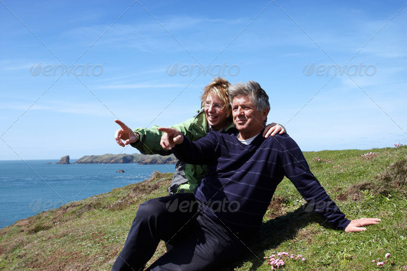 A mature couple sitting on the coastal path - Stock Photo - Images