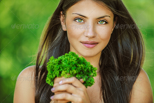 woman with bare shoulders holding bunch of parsley - Stock Photo - Images