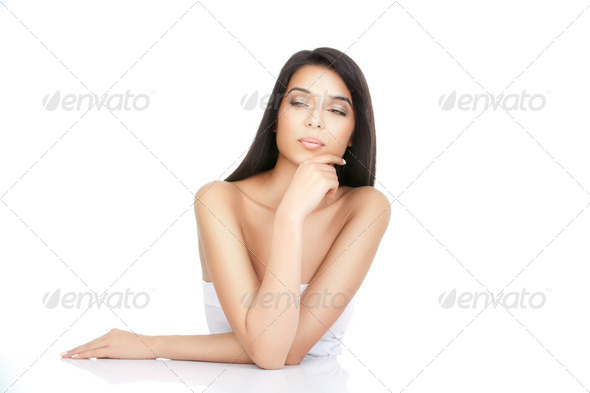 a beauty portrait of a young woman with a hand to her chin - Stock Photo - Images