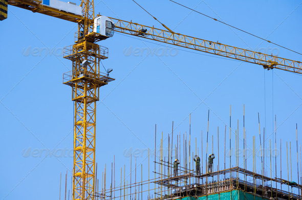 Construction workesr working under Cranes on construction site - Stock Photo - Images