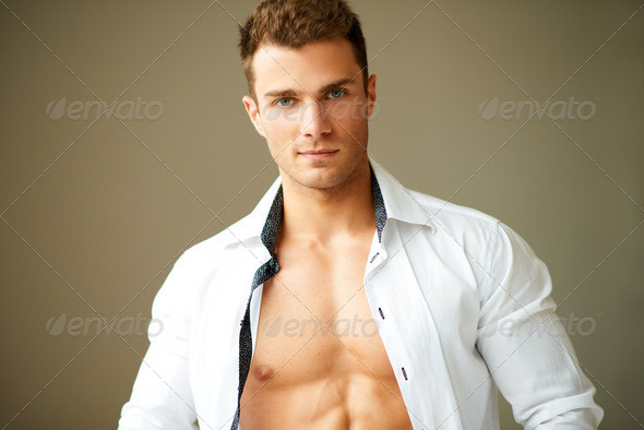 Portrait of muscular man posing in white shirt - Stock Photo - Images