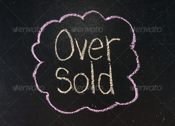 Stock Exchange word OVER SOLD made with chalk on a blackboard.