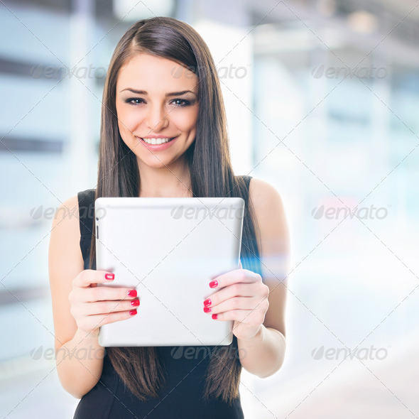 Businesswoman in front of office building holding tablet - Stock Photo - Images