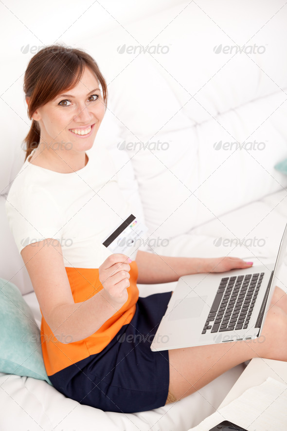 woman with card in hand and laptop
