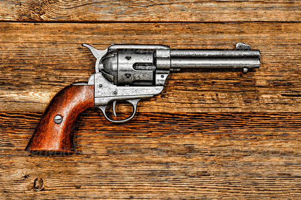 American West legend Peacemaker old style revolver antique six-shooter weapon gun on aged wood board