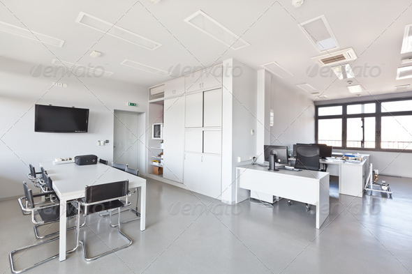 Modern office with white furniture, cupboard, conference desk and walls and with plasma TV on the wall