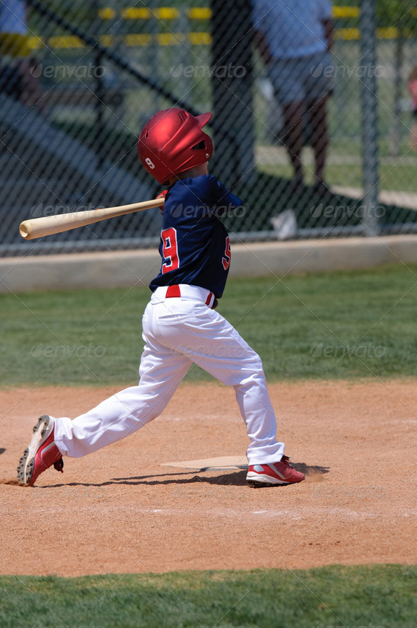 Little league baseball boy swinging a bat.