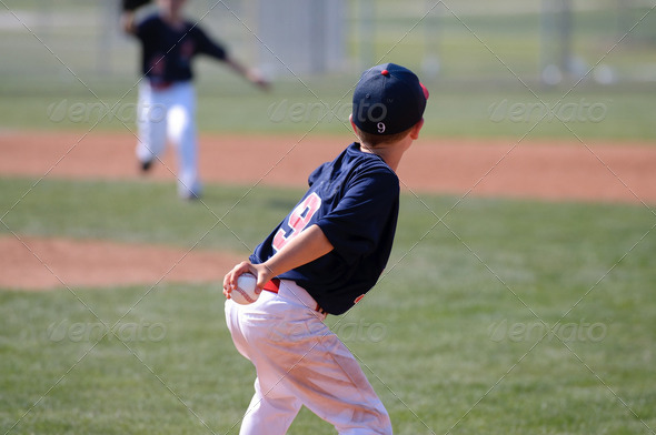 Little league baseball boy throwing ball.