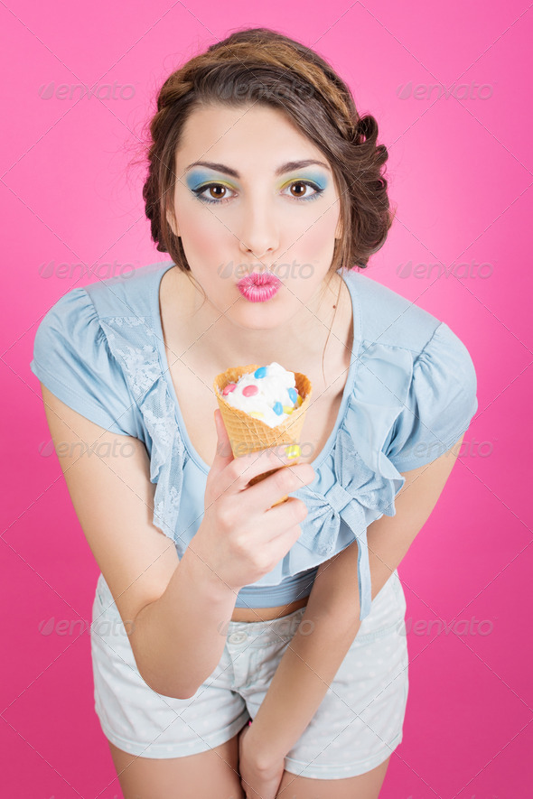 Cute young retro woman eating ice-cream in cornet - Stock Photo - Images