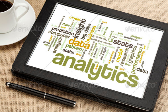 cloud of words or tags related to analytics and data analysis on a digital tablet with a cup of tea