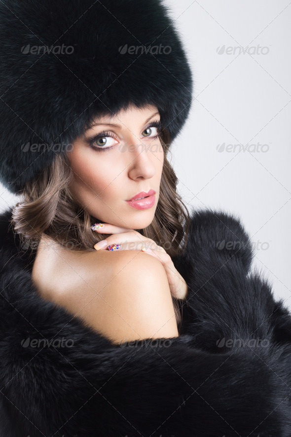 Glamorous young woman wearing black fur coat and hat - Stock Photo - Images