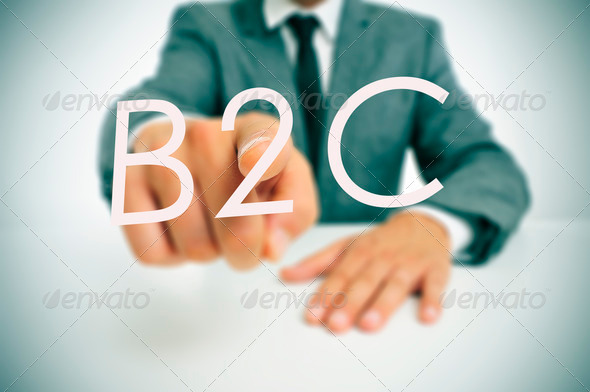 man wearing a suit sitting in a table pointing to the word B2C, business-to-consumer, written in the foreground