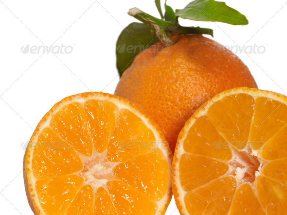 fresh halved orange and orange fruit with leaves