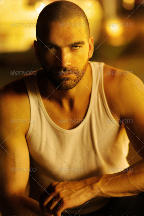 Classic portrait of a sexy moody man in golden light and shadow