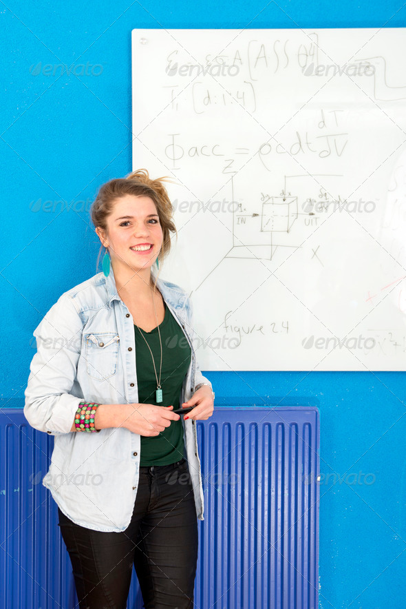 Smart student standing next to a complex differential equation, she’s just solved on the white board behind her