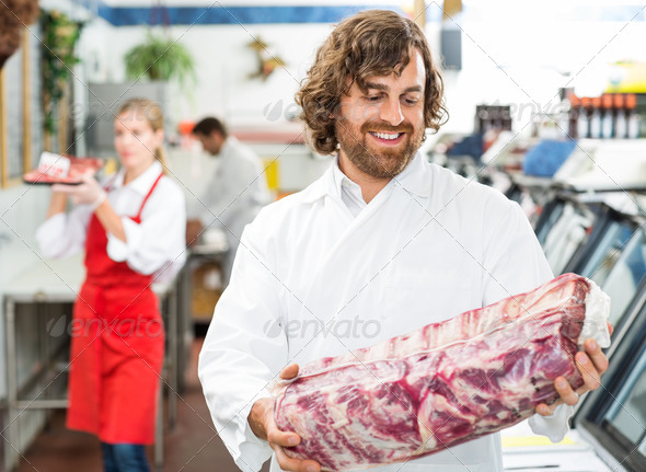 Happy Butcher Looking At Meat Package