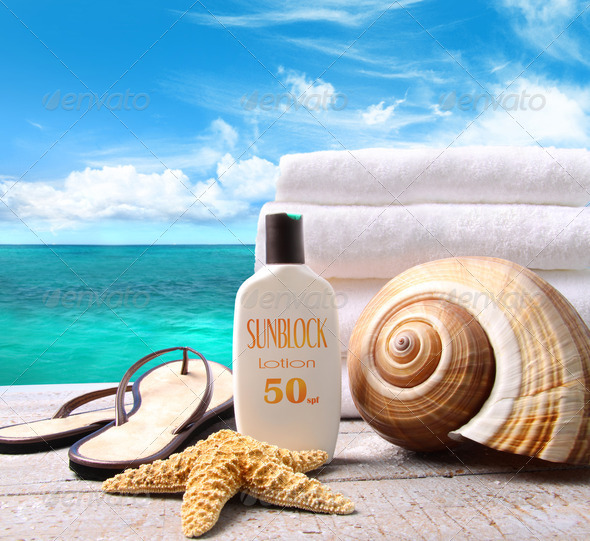 Sunblock lotion and towels and ocean scene