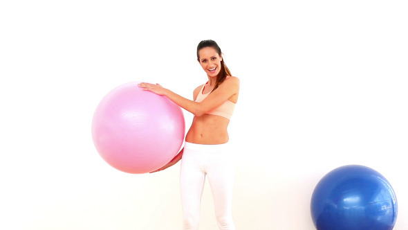 Fit Model Holding Exercise Ball And Smiling Fit Model Holding Exercise Ball And Smiling