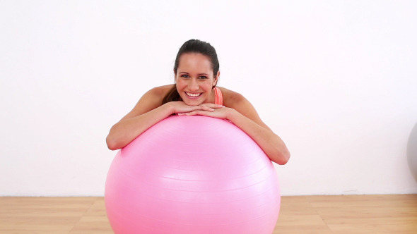 Fit Model Leaning On Pink Exercise Ball Smiling Fit Model Leaning On Pink Exercise Ball Smiling